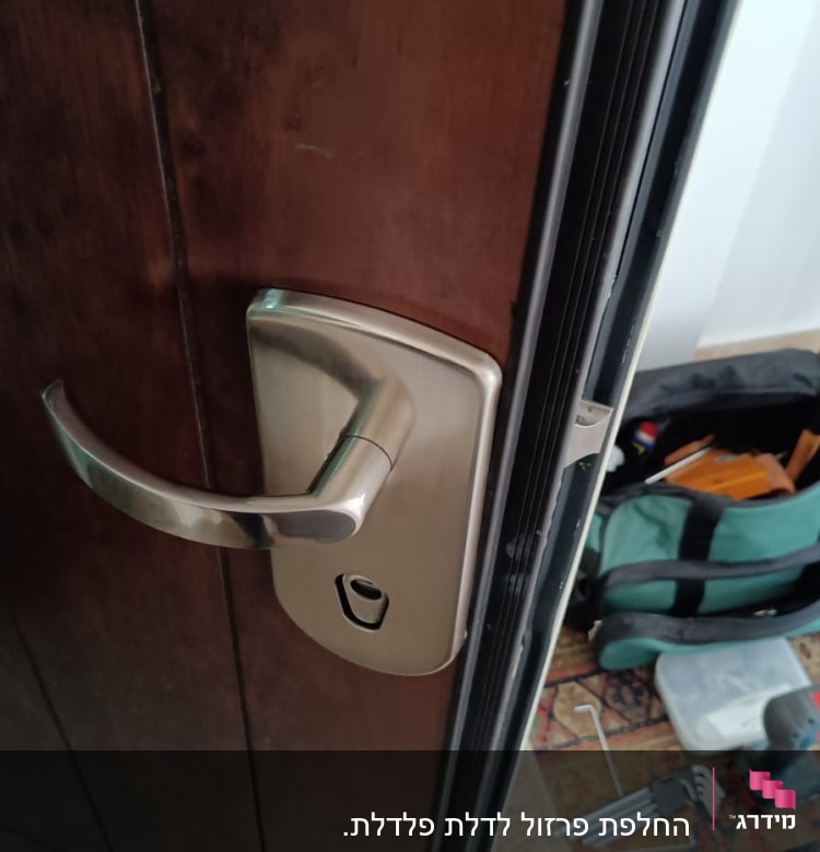 ידית דלת מתכתית עם מנעול, כלים על הרצפה